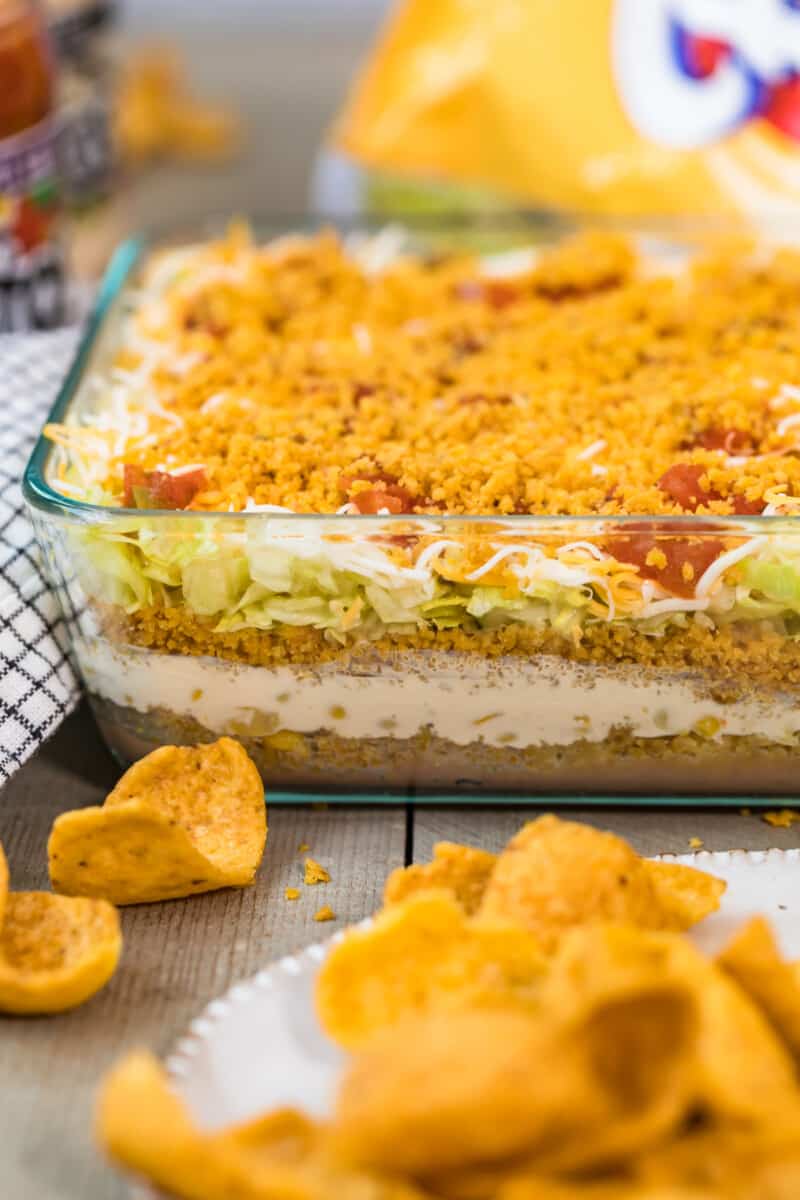 Mexican layer dip with fritos in dish.