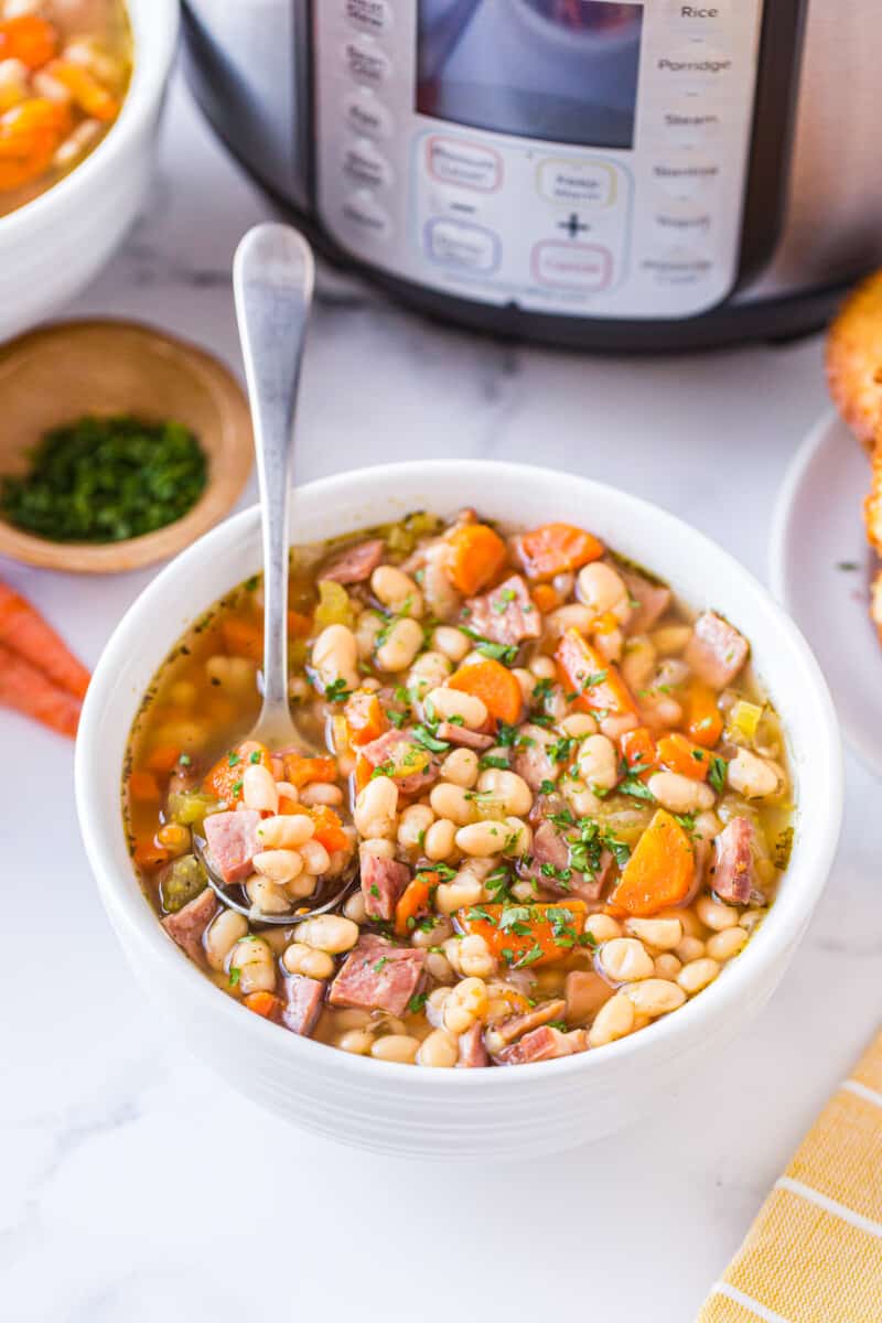 spoon in bowl of instant pot ham and bean soup