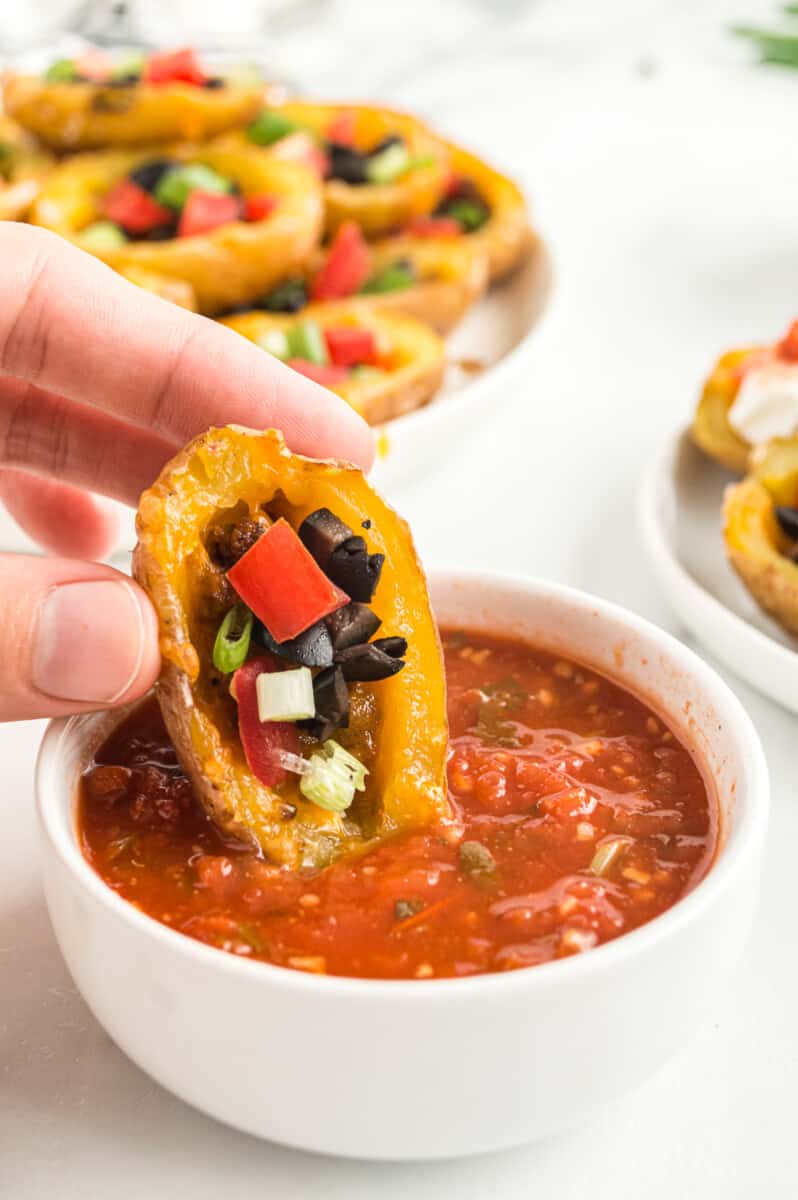 dipping mexican potato skin in salsa