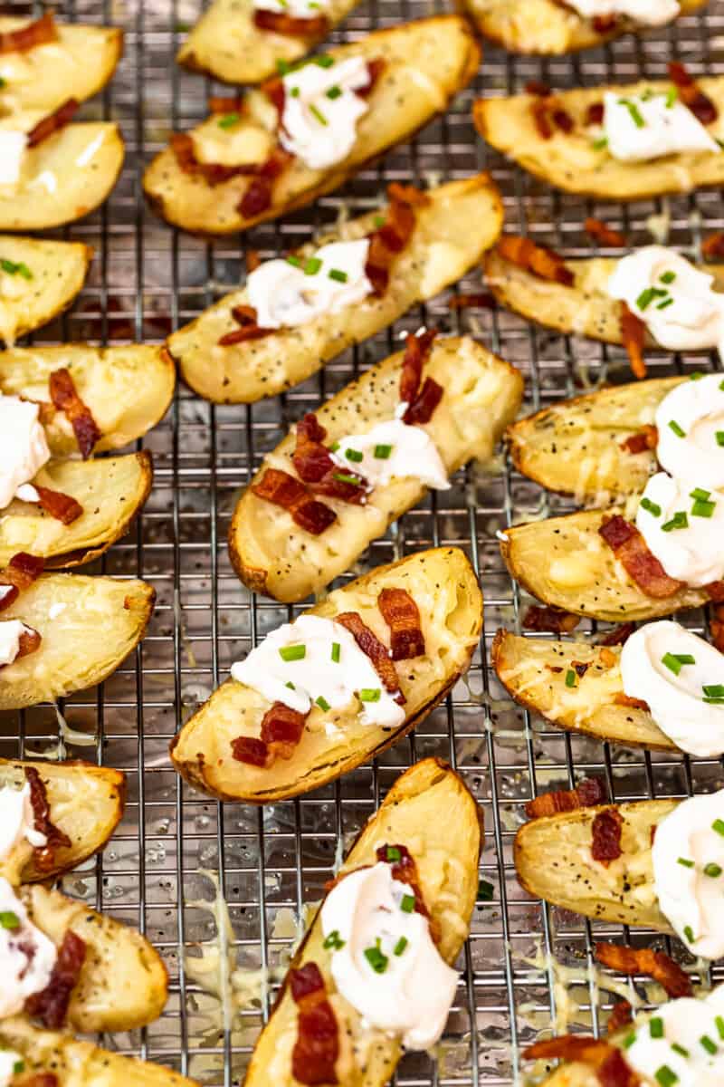 potato skins on baking sheet with sour cream, bacon, and chives