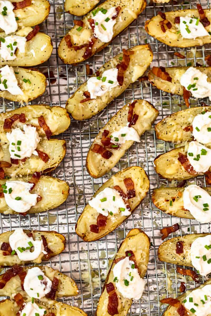 potato skins on baking sheet with sour cream, bacon, and chives