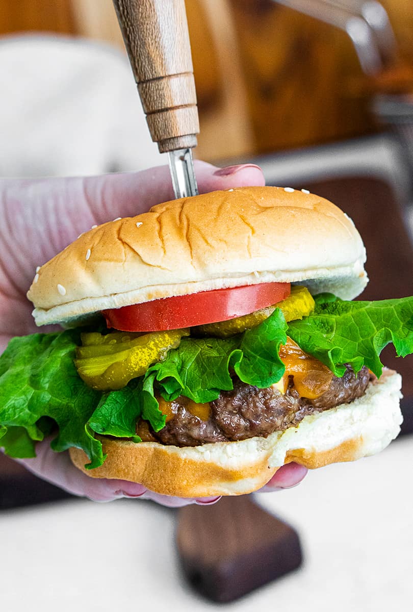 holding up air fryer cheeseburger