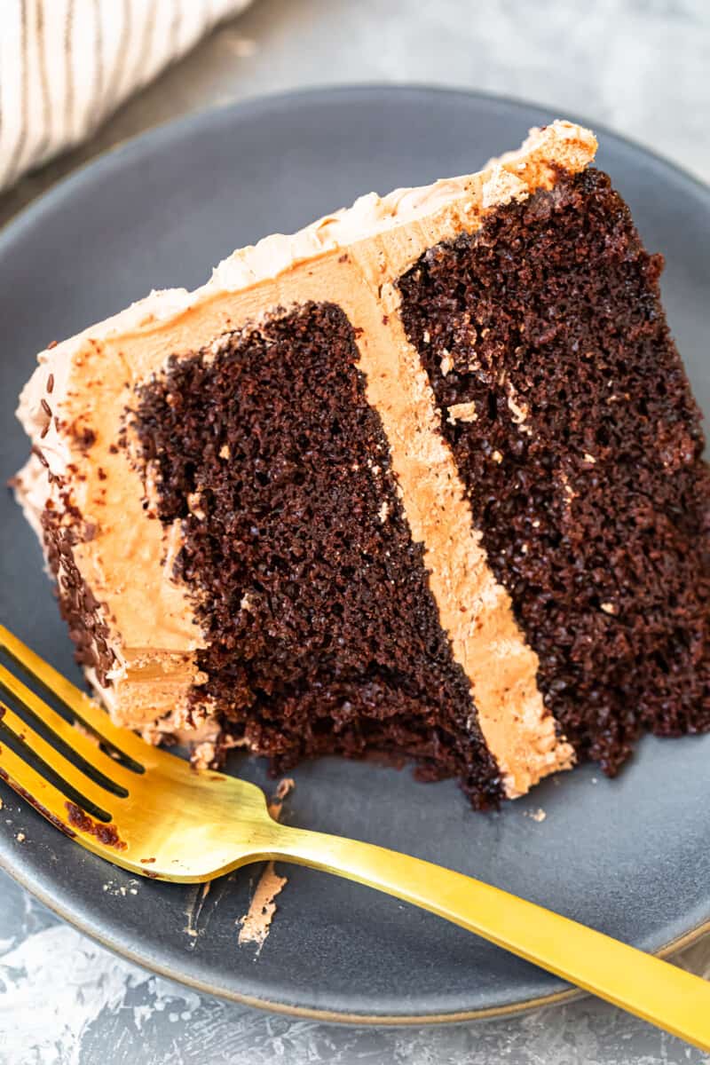 slice of chocolate cake with chocolate frosting on gray plate