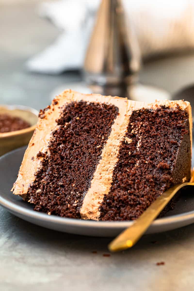 slice of chocolate cake with chocolate frosting on gray plate