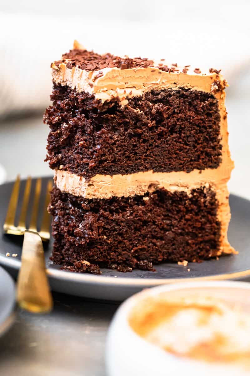 slice of chocolate cake with chocolate frosting on gray plate