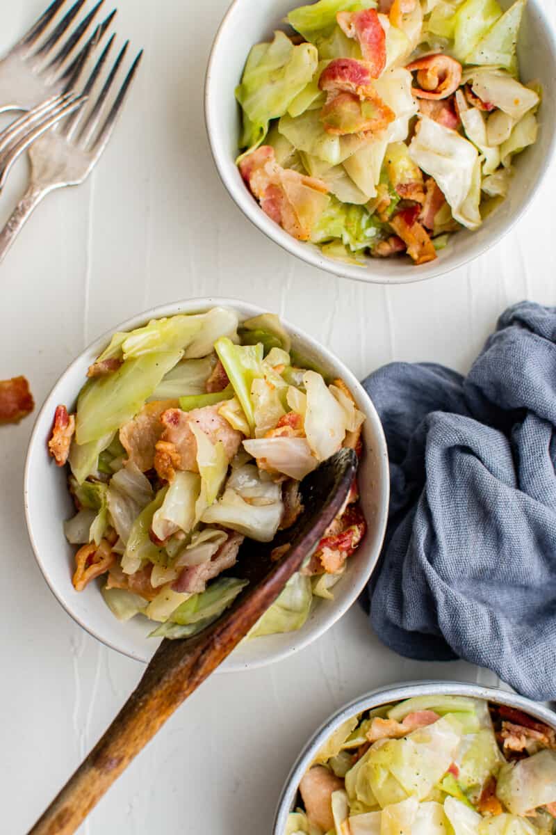 bowls of cooked cabbage and bacon