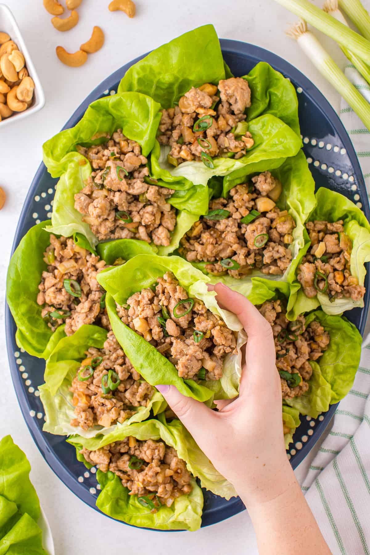 lifting up chicken lettuce wrap from platter