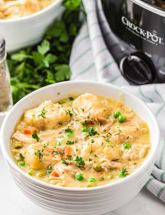 bowl of crockpot chicken and dumplings garnished with parsley