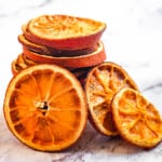 Dried orange slices arranged on marble surface.