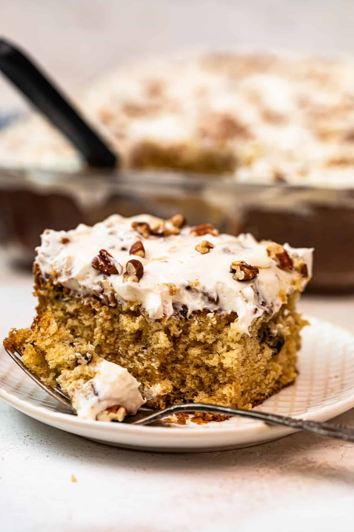 slice of italian cream cake with Cream Cheese Pecan Frosting with bite out
