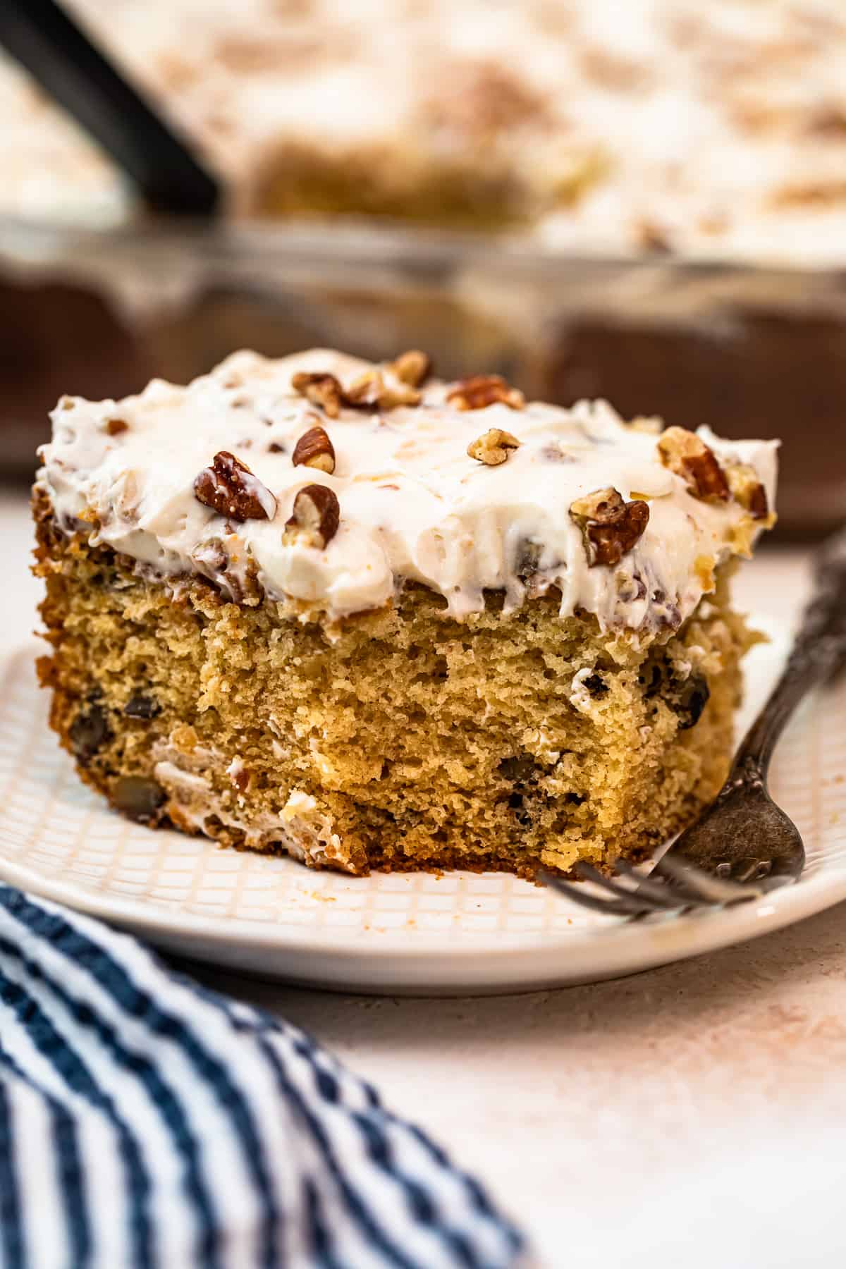 slice of italian cream cake with Cream Cheese Pecan Frosting with bite out