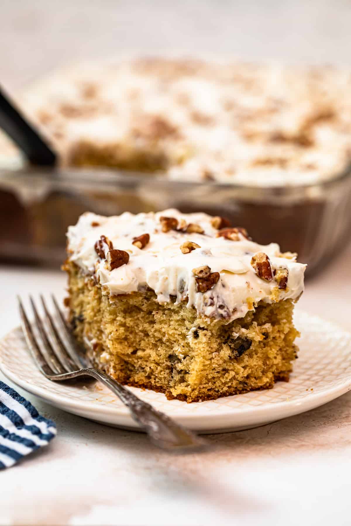 slice of italian cream cake with Cream Cheese Pecan Frosting on white plate