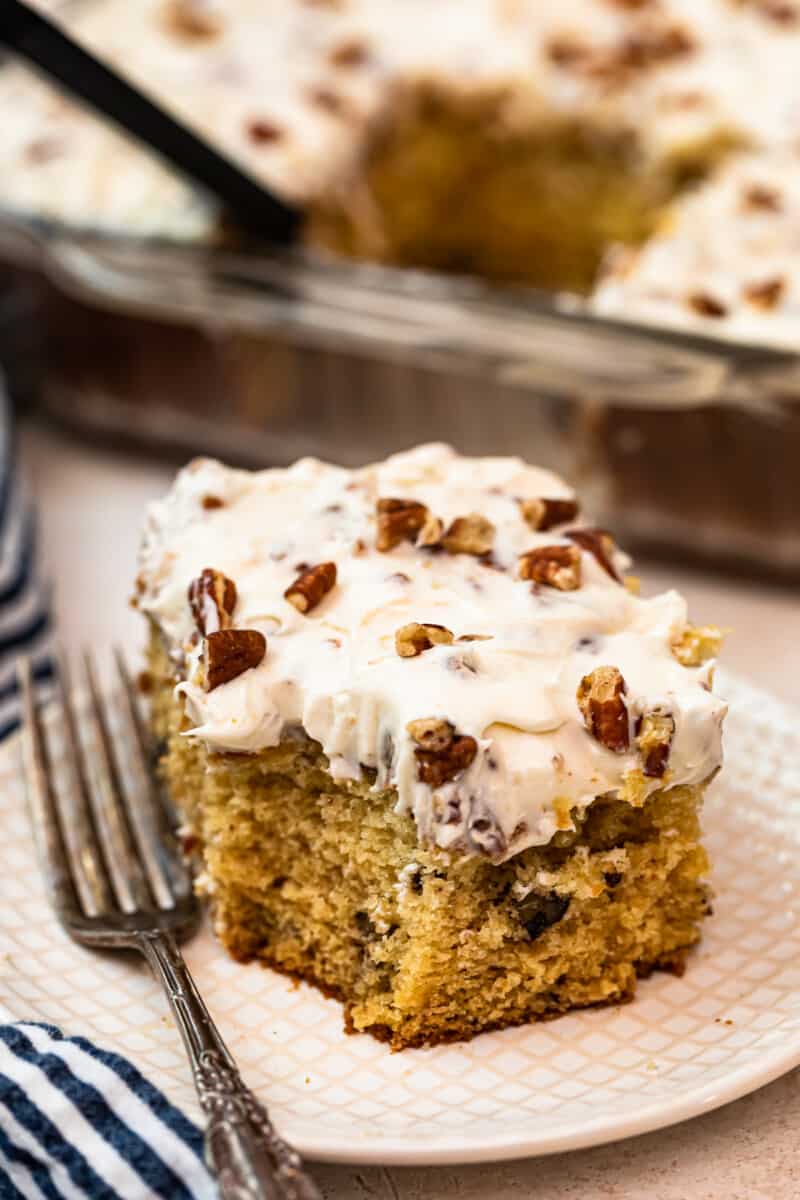 slice of italian cream cake with Cream Cheese Pecan Frosting on white plate