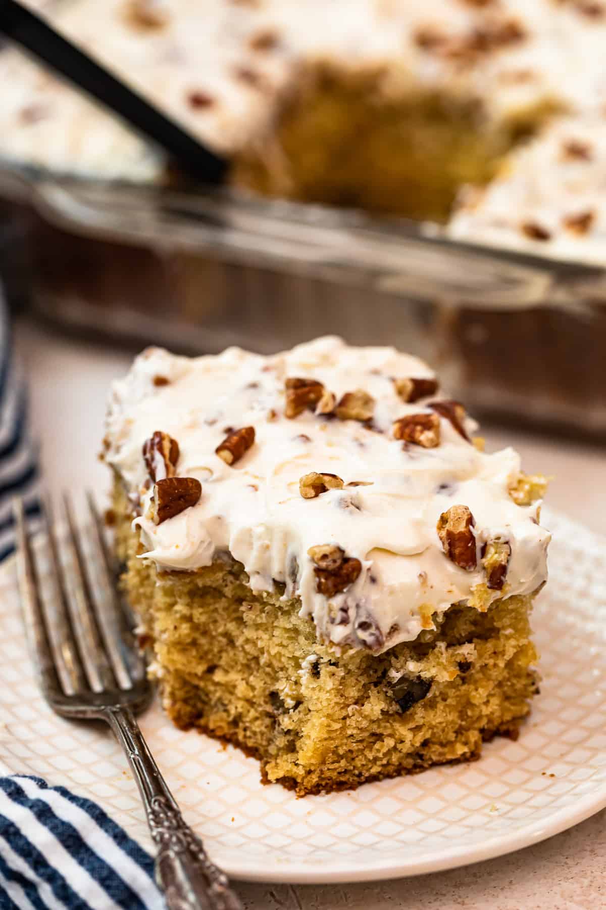 slice of italian cream cake with Cream Cheese Pecan Frosting on white plate