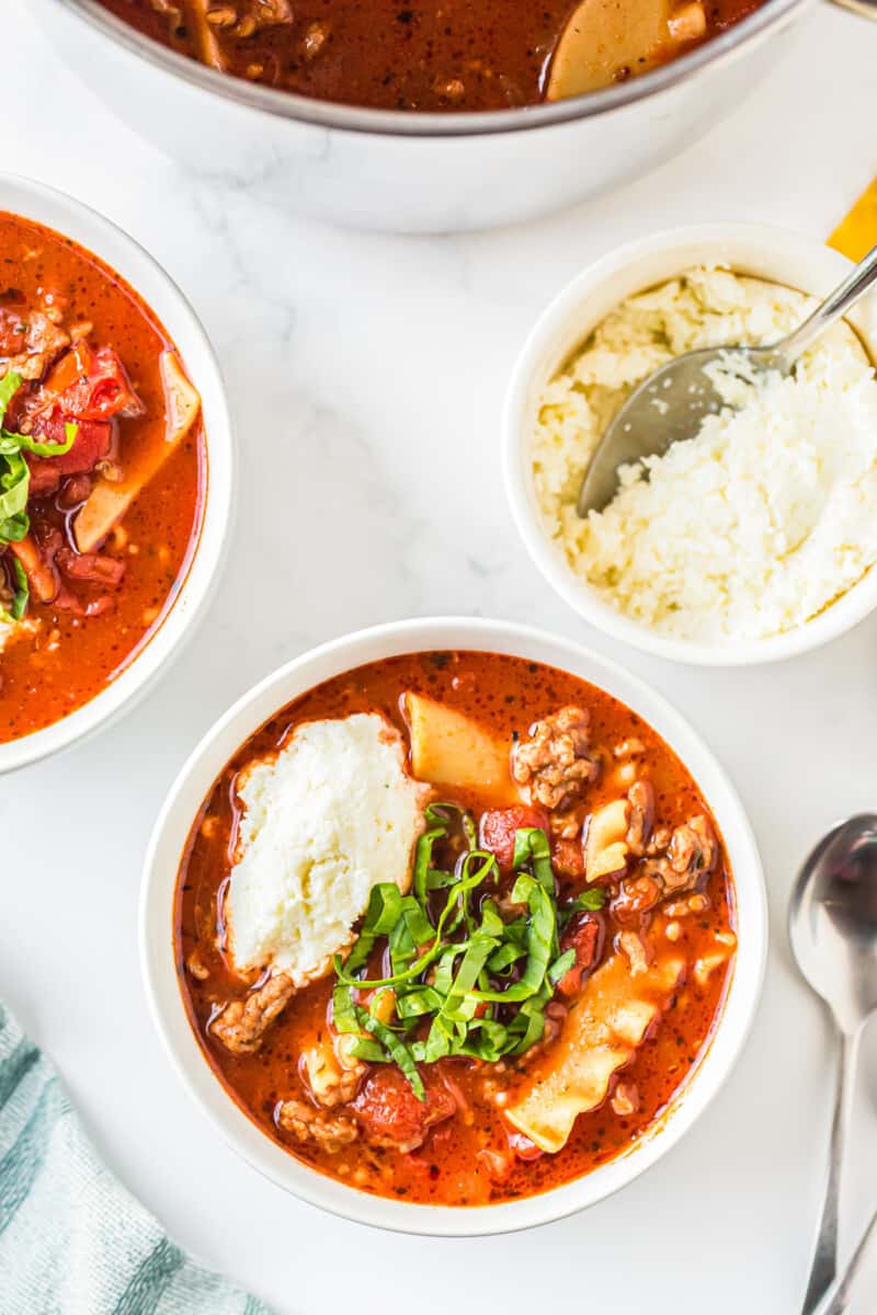 overhead image of lasagna soup garnished with ricotta and basil