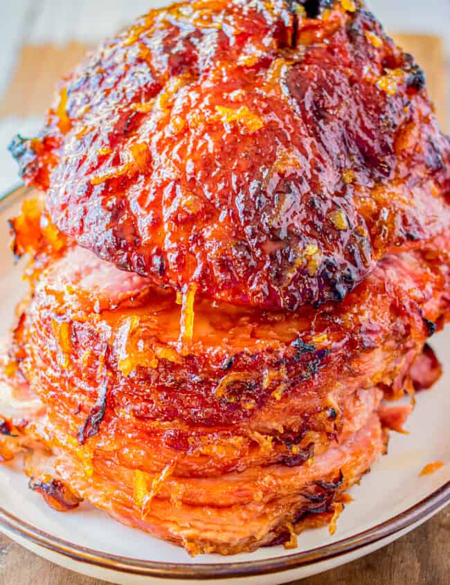 orange honey glazed ham on white plate