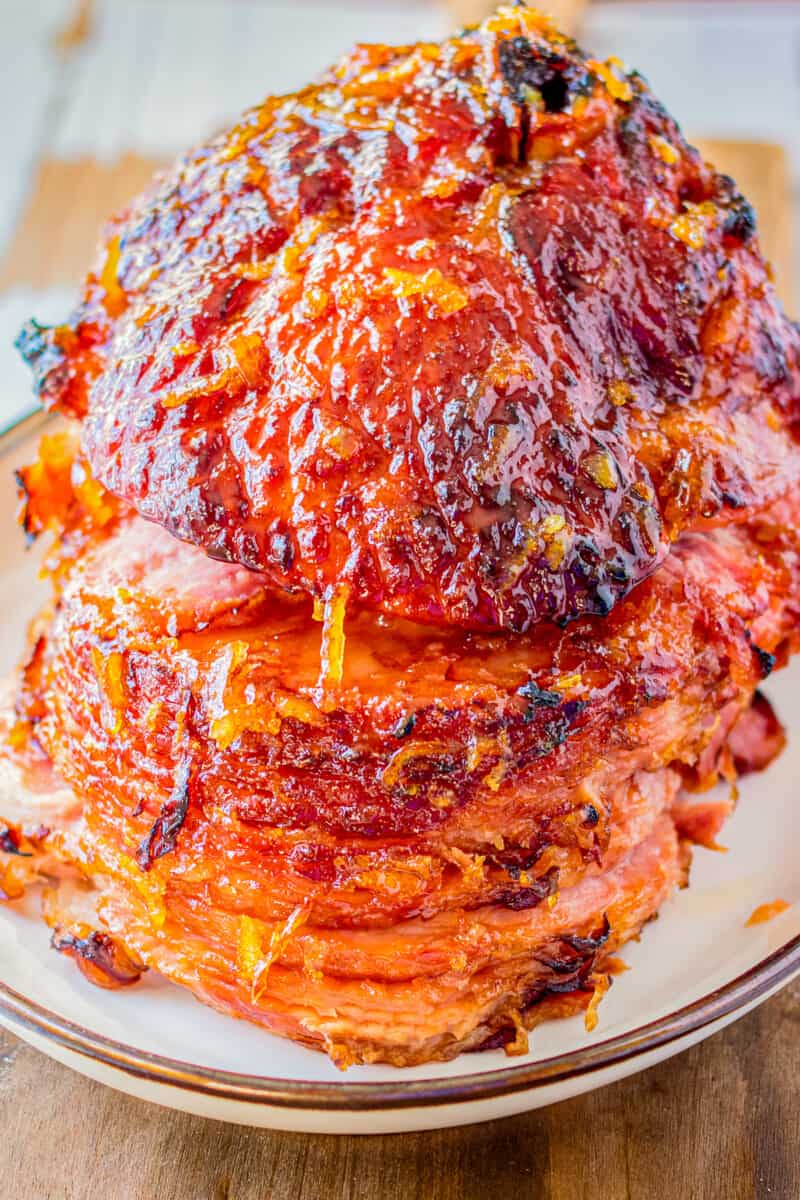 orange honey glazed ham on white plate