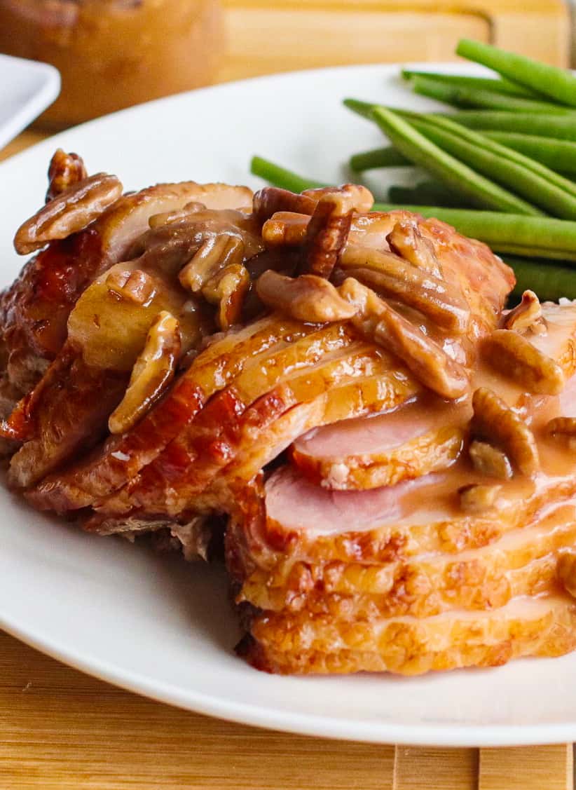 up close slices of spiral ham topped with pecan bourbon glaze