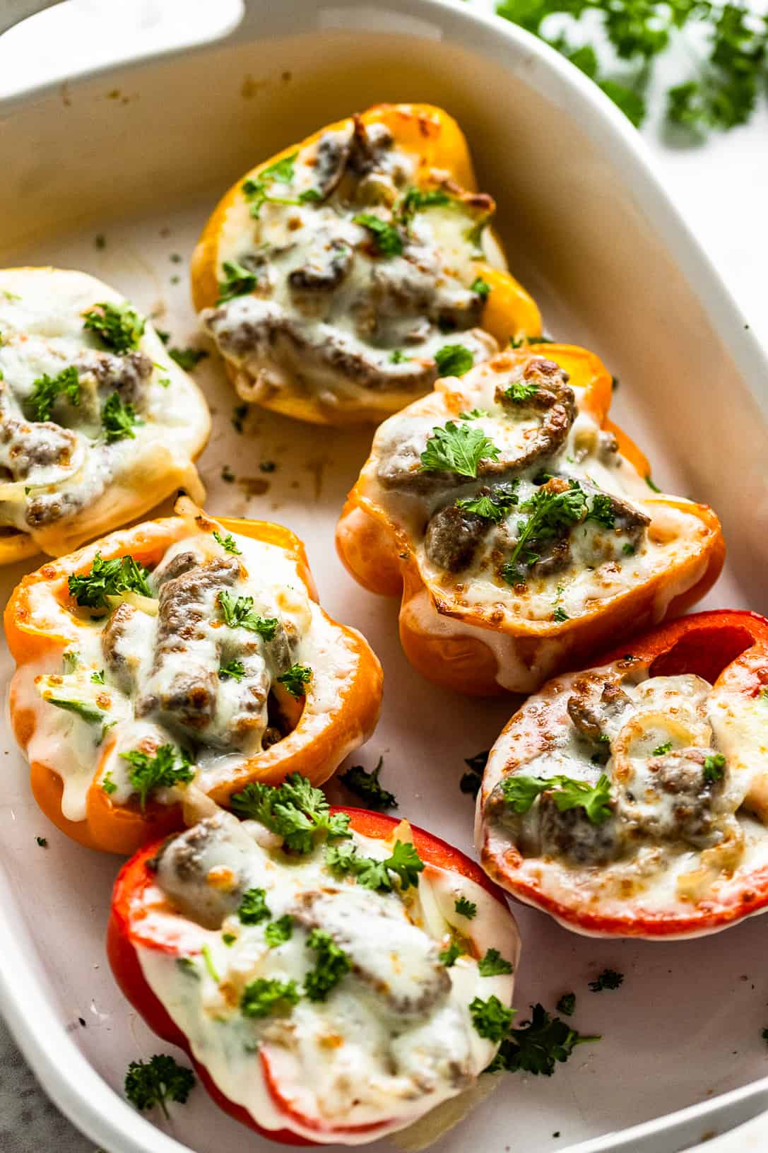 Philly cheesesteak stuffed peppers in a baking dish.
