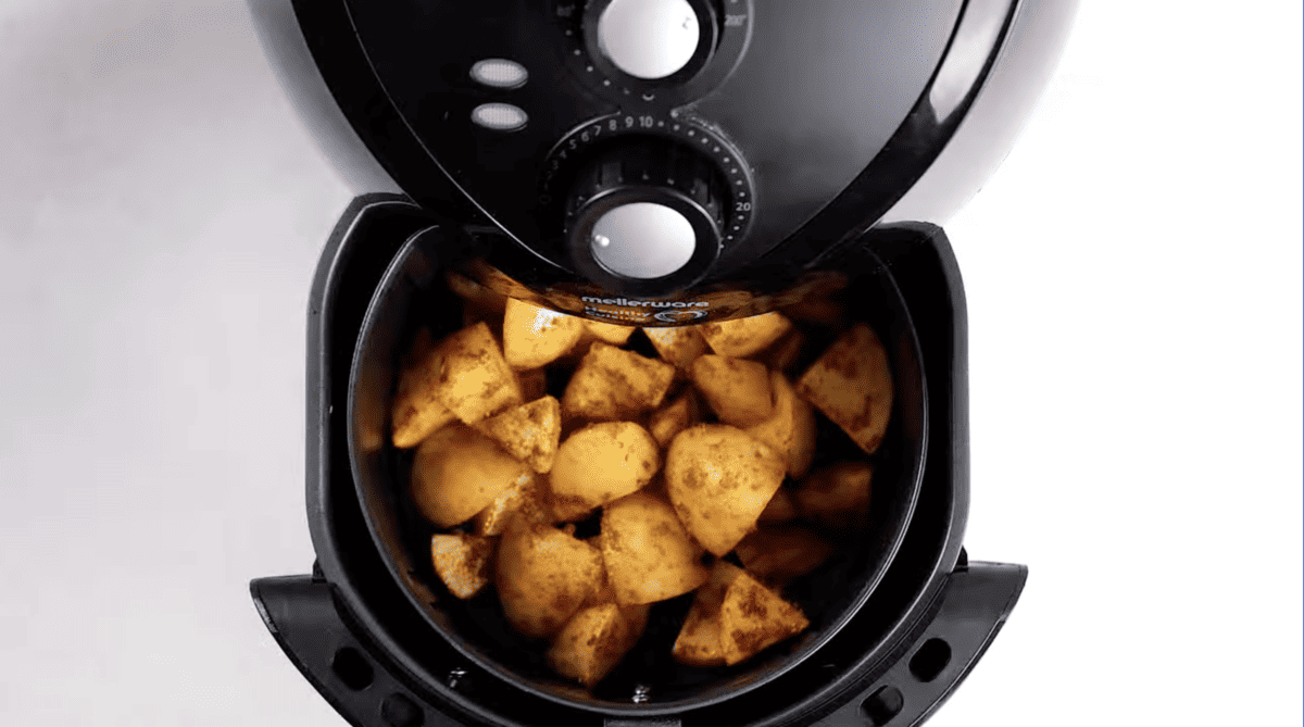 seasoned potatoes in an air fryer basket.