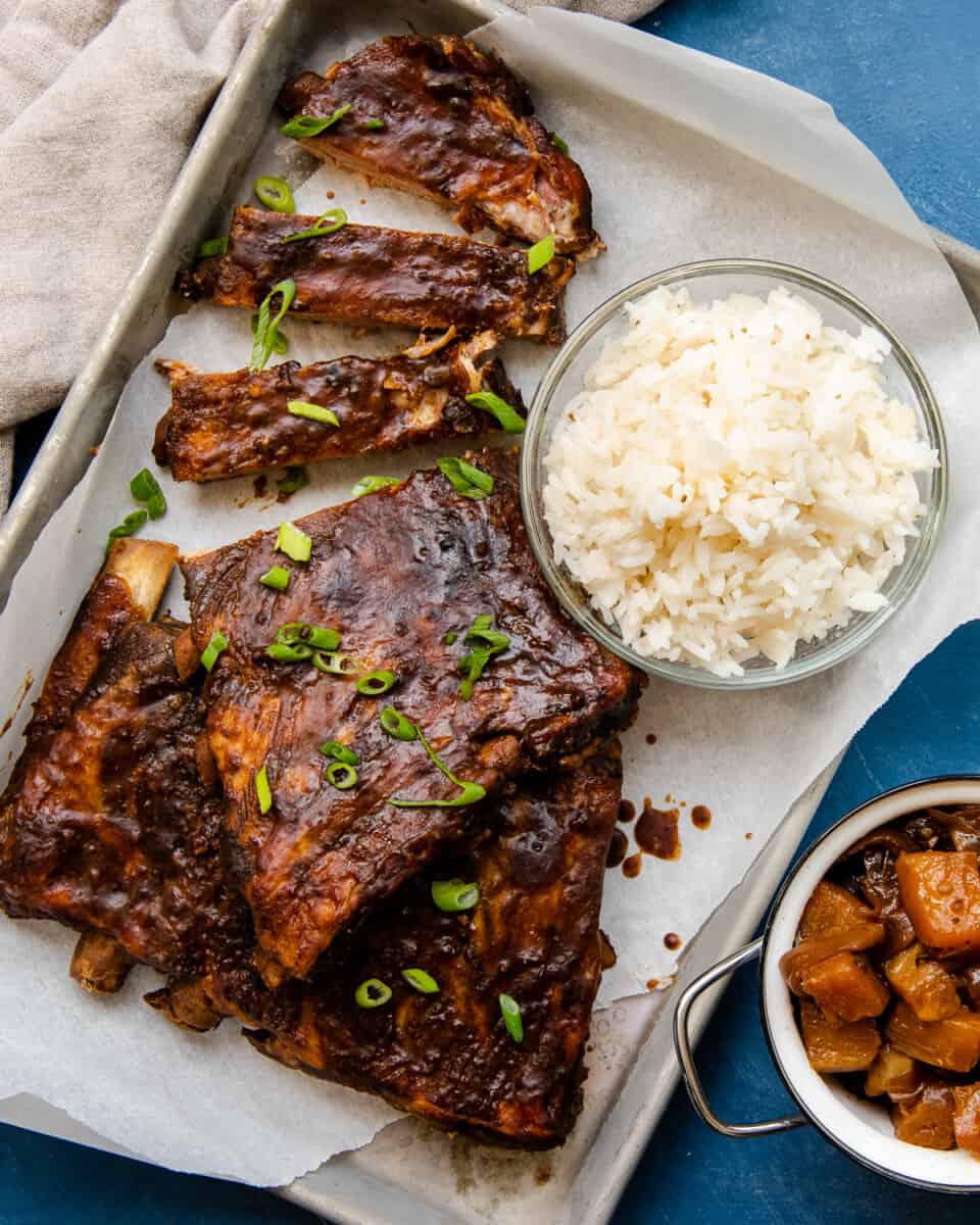 crockpot hawaiian ribs with bowl of rice on sheet pan