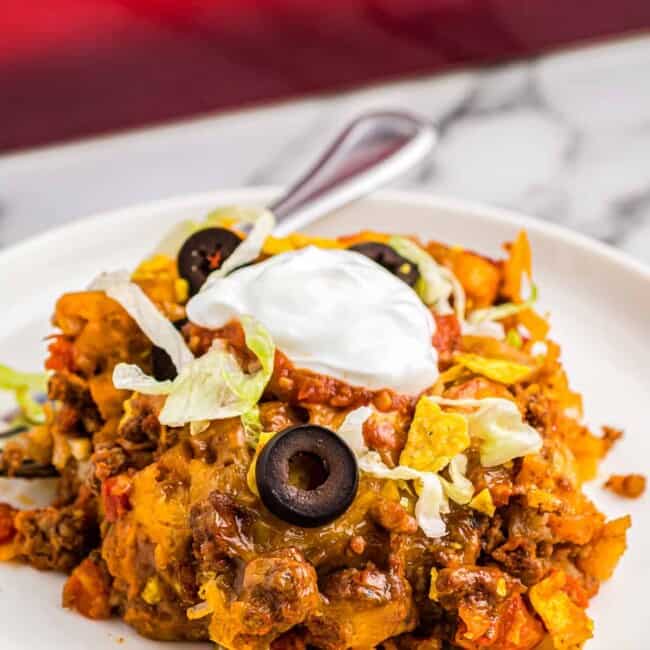 taco casserole on plate garnished with sour cream