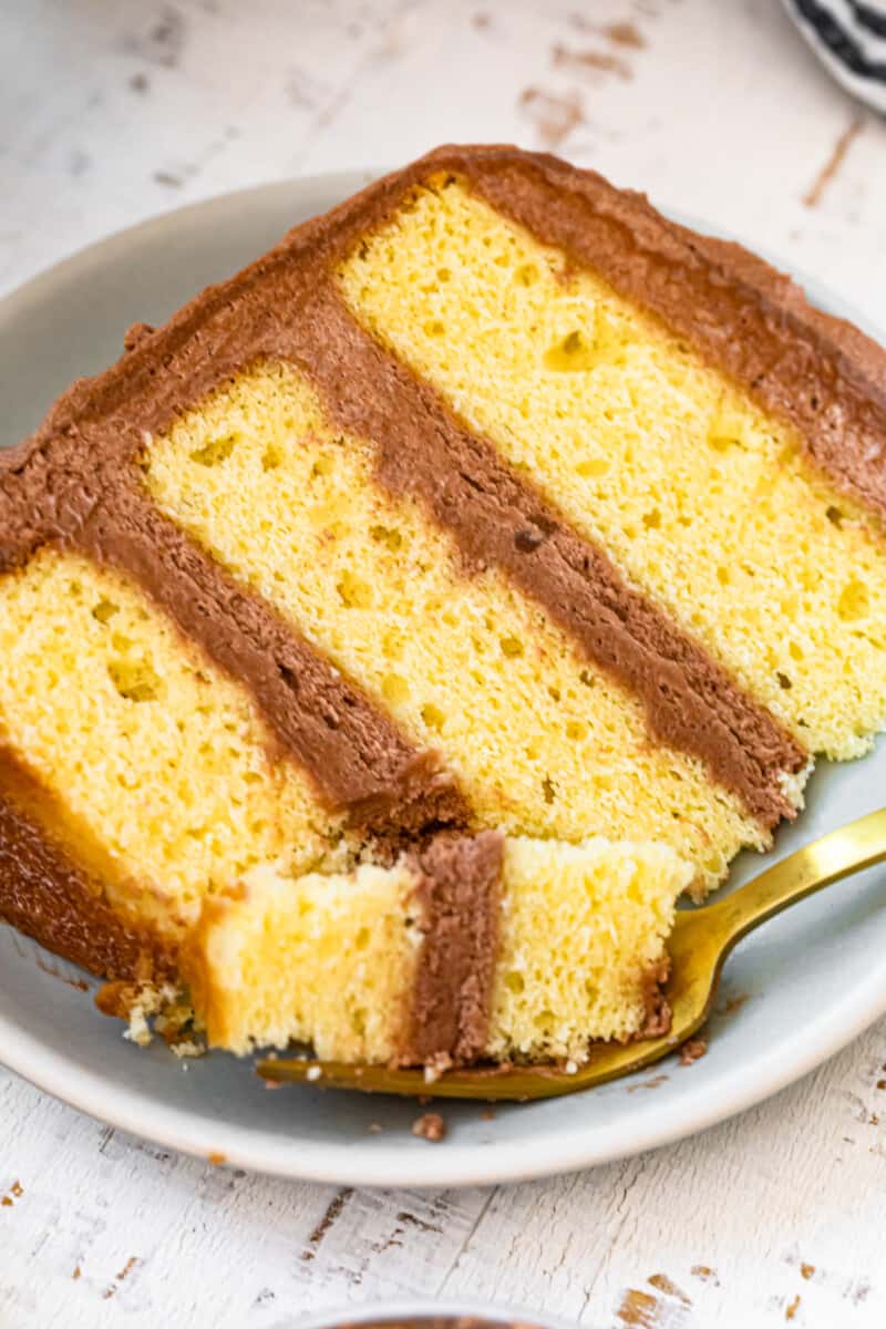 yellow cake laying on plate with milk chocolate buttercream