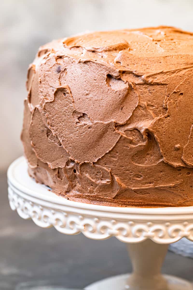 up close yellow cake frosted with milk chocolate buttercream on cake stand