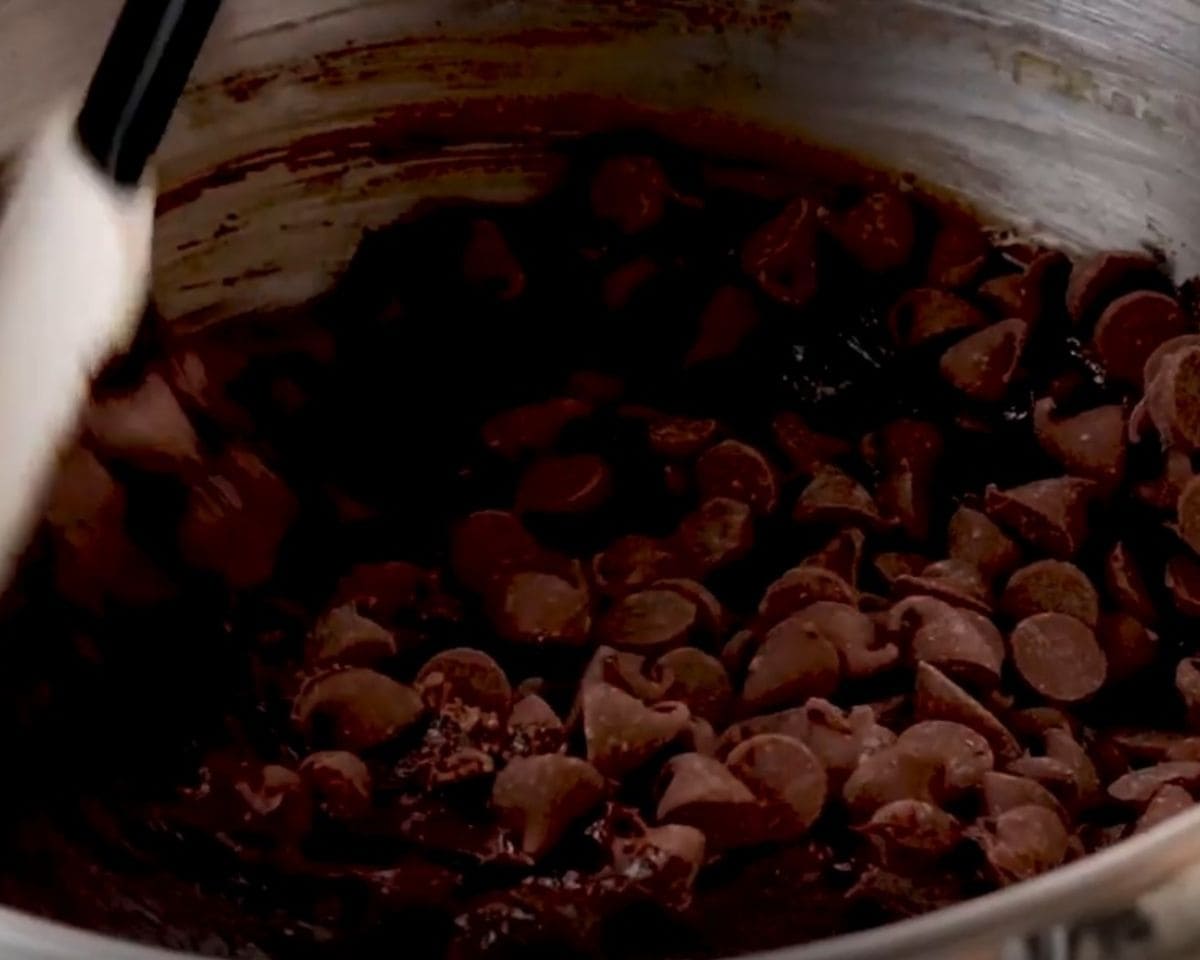 Adding chocolate chips to the cookie batter. - 6