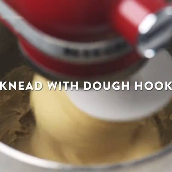 a mixer is mixing dough with dough hooks.