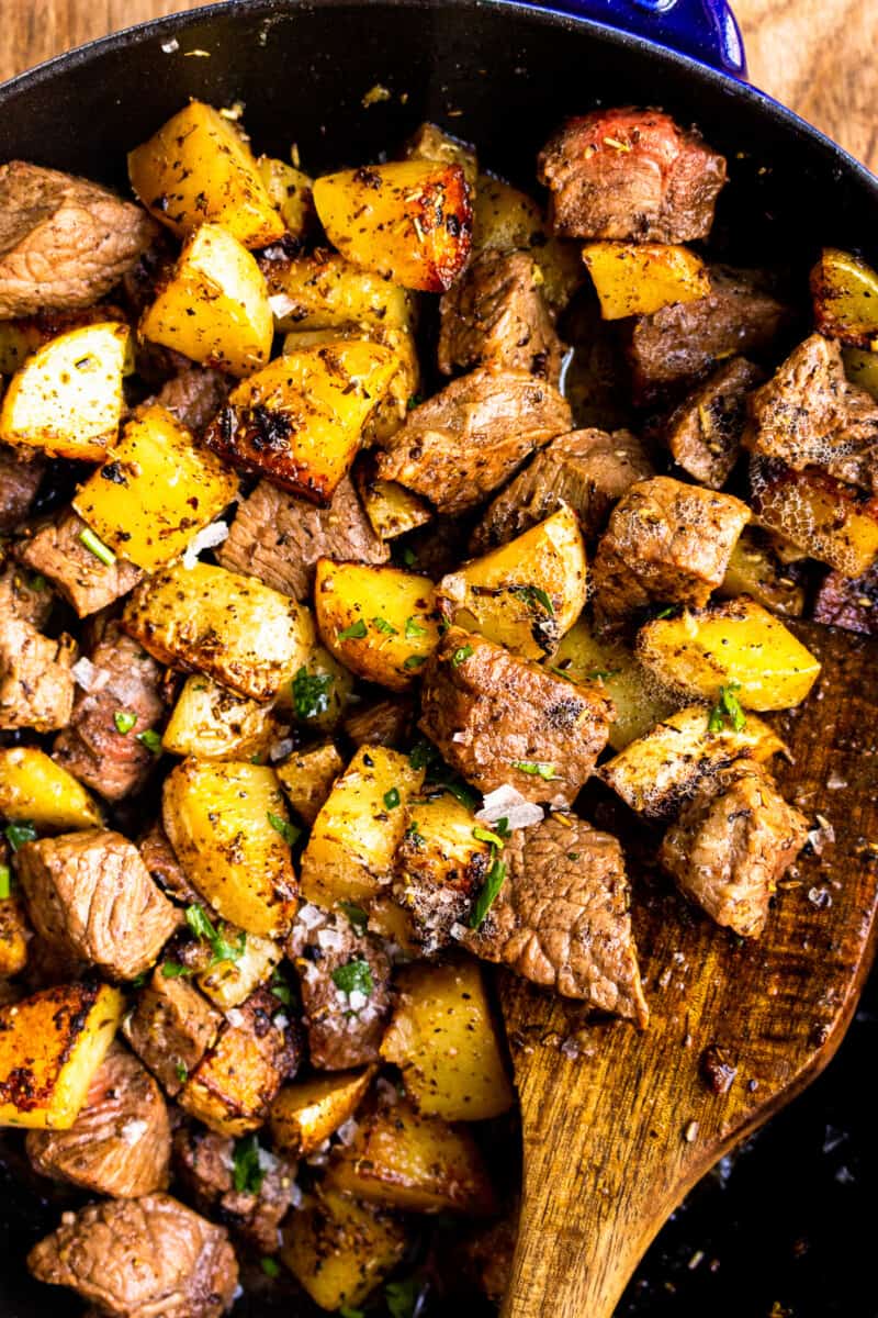 up close garlic butter steak bites with potatoes in skillet