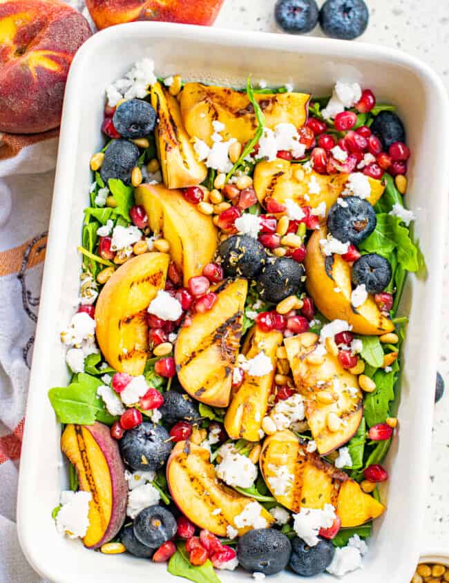 overhead grilled peach salad in white serving dish