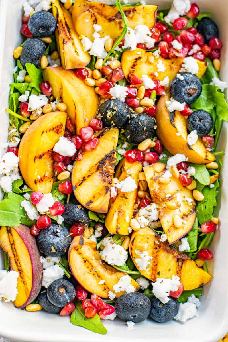 overhead grilled peach salad in white serving dish