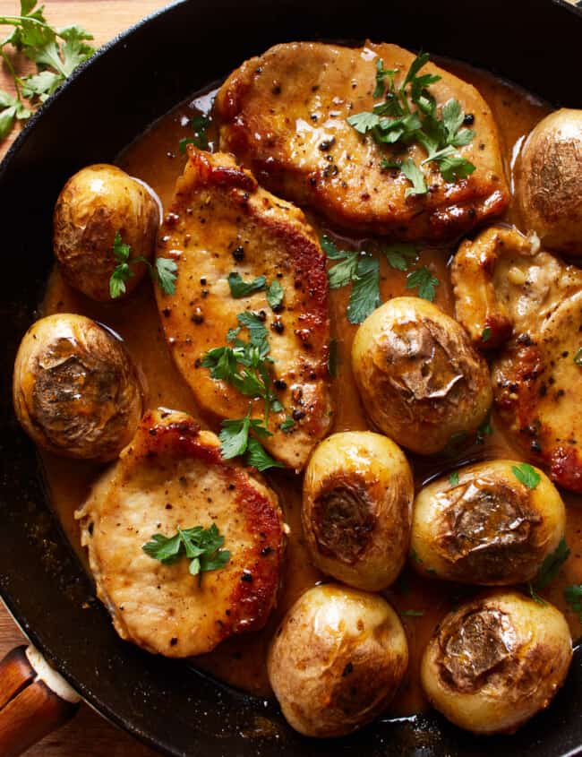 overhead view of honey mustard pork chops and potatoes in a skillet.