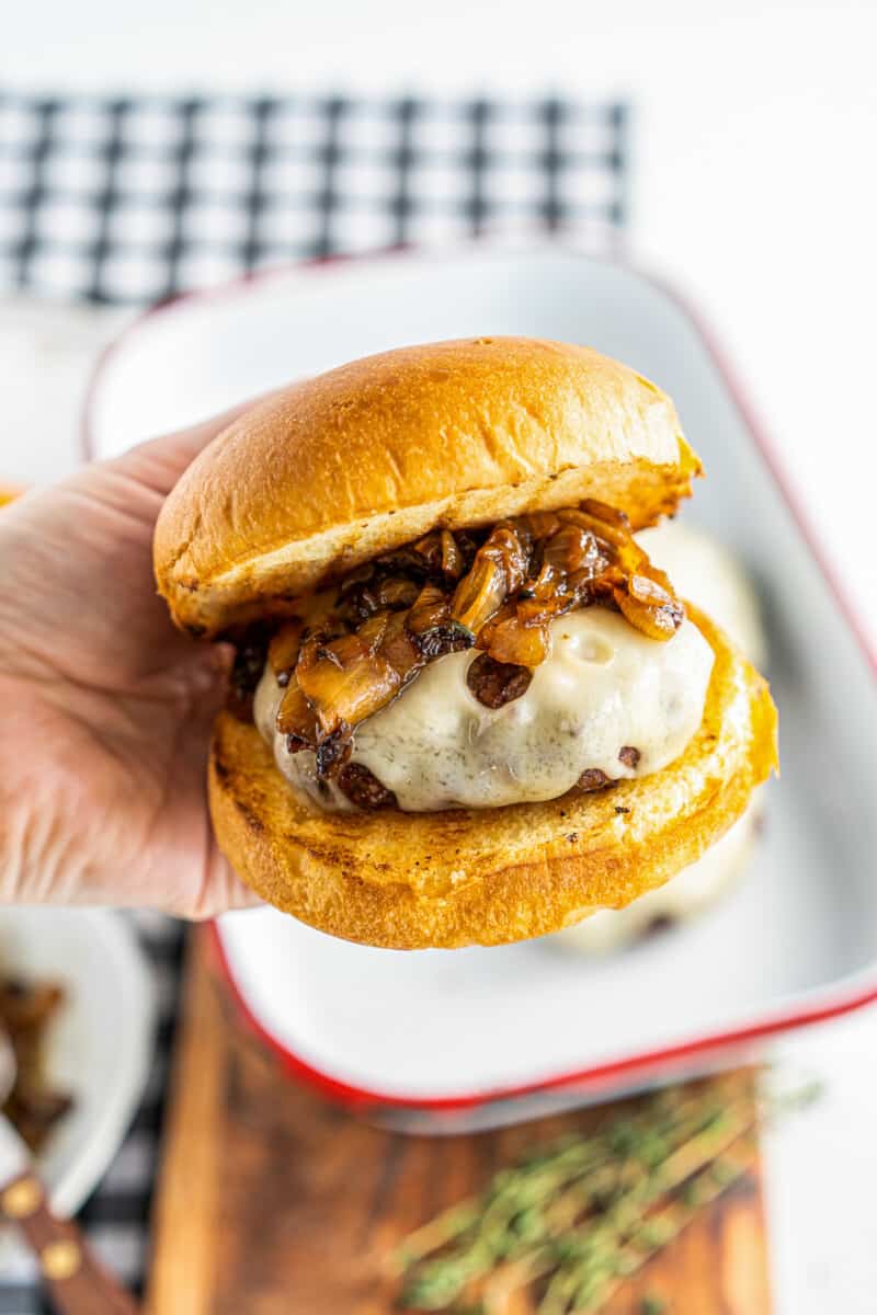 holding up grilled onion swiss burger