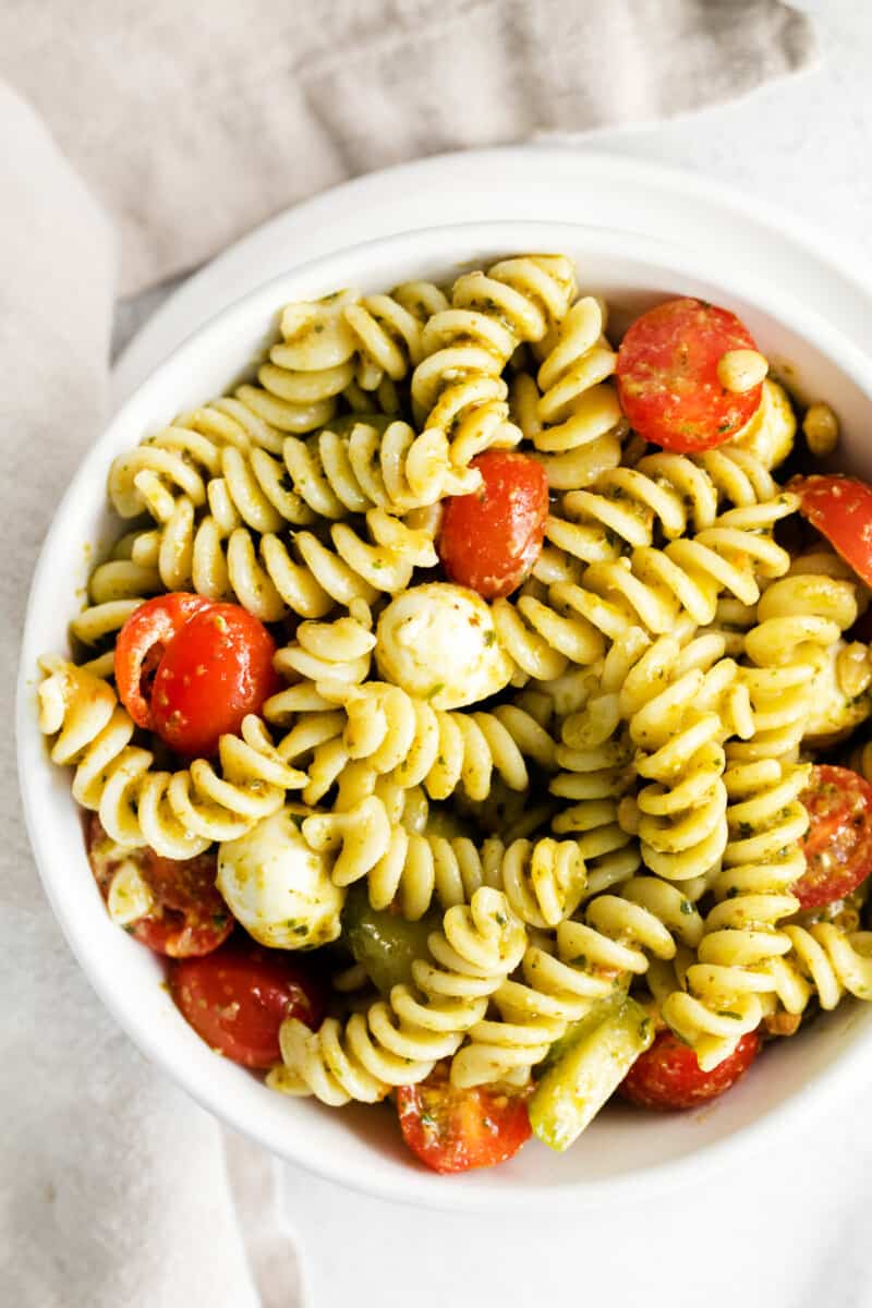 overhead pesto pasta salad in white bowl