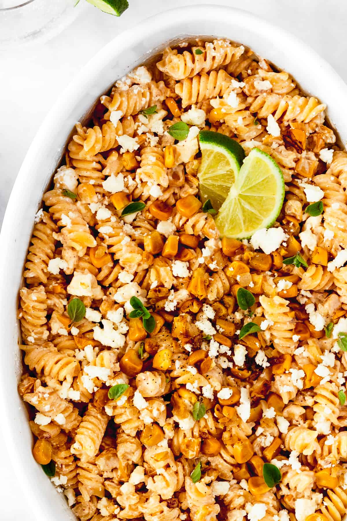 up close white serving platter with street corn pasta salad