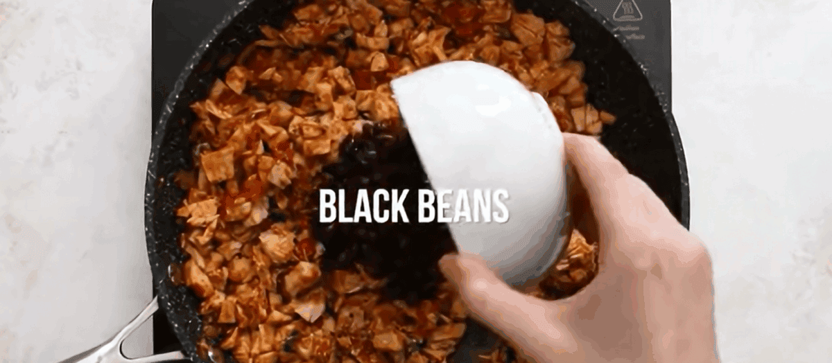 Adding lime juice and beans to the pot.
