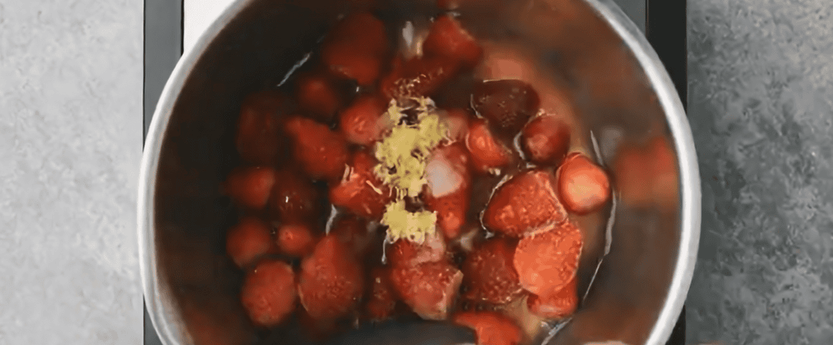 Simmering strawberries in a pot to make the strawberry filling.