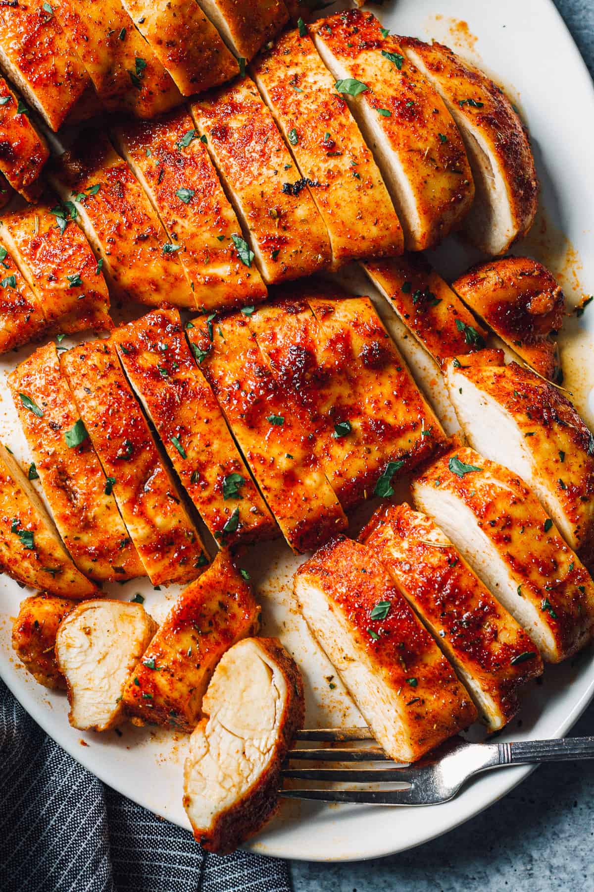baked chicken breasts sliced on white platter