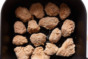 uncooked air fryer chicken nuggets in an air fryer basket.