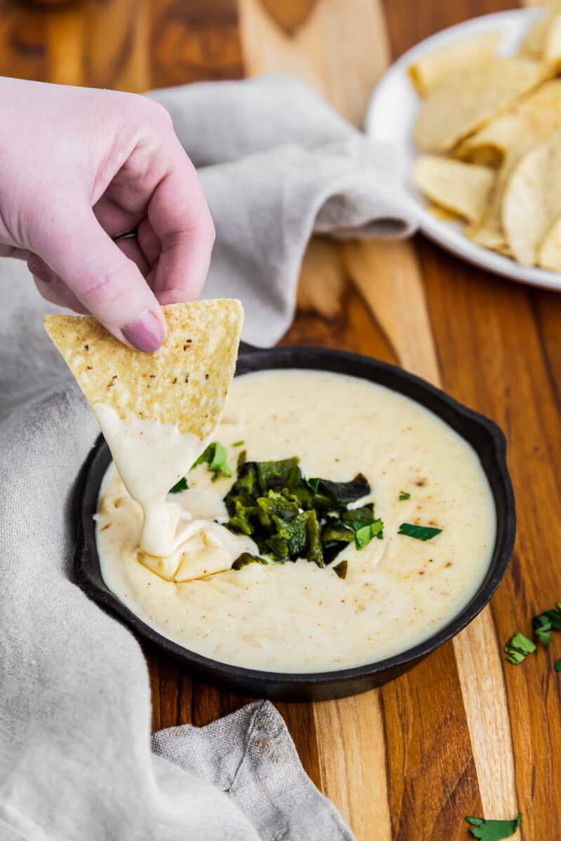 dipping chip in poblano queso