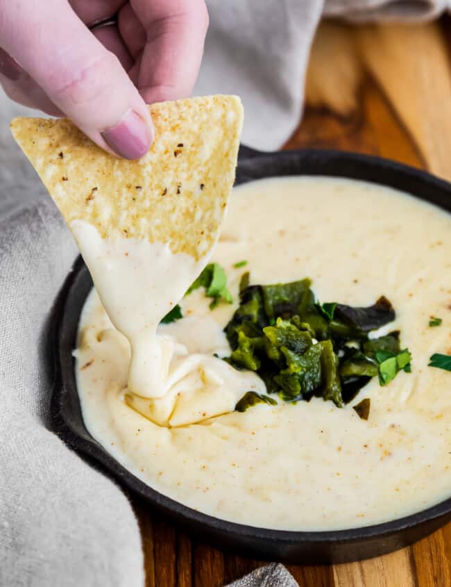 dipping chip in poblano queso