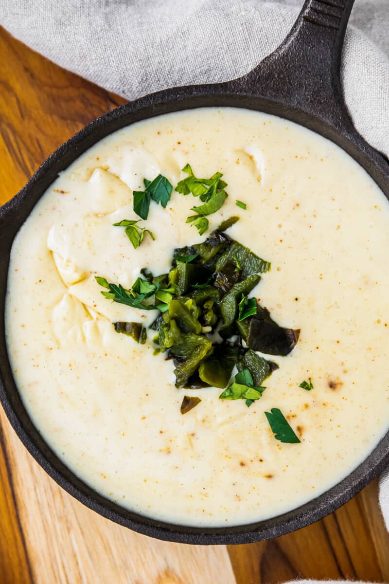 up close spicy poblano queso in small cast iron skillet