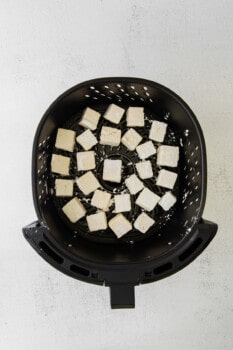 cubes of air fryer teriyaki tofu in an air fryer basket.