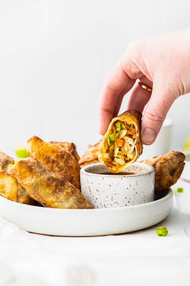 dipping egg fryer egg roll in soy sauce