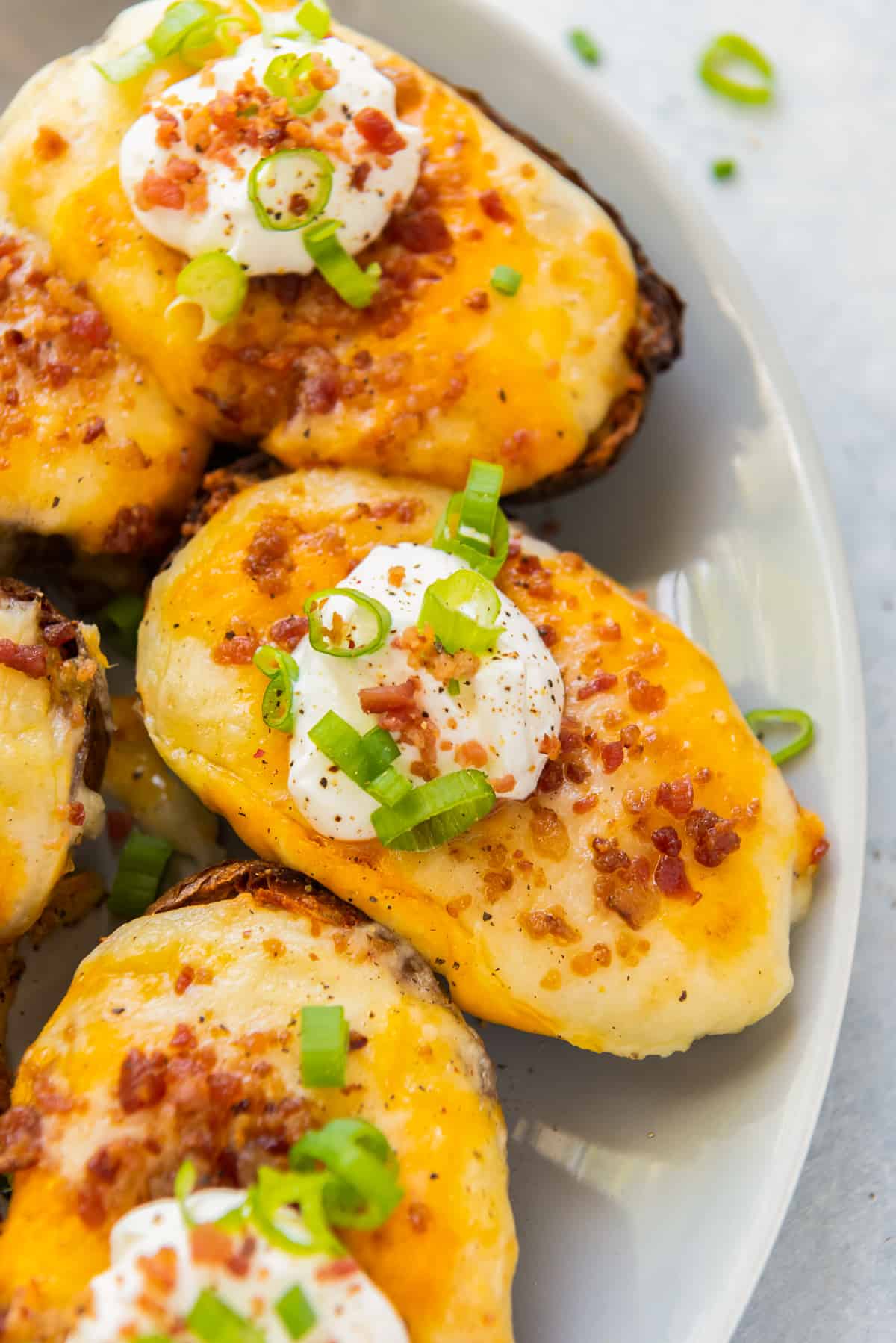 air fried twice baked potato garnished with sour cream, bacon, and green onions