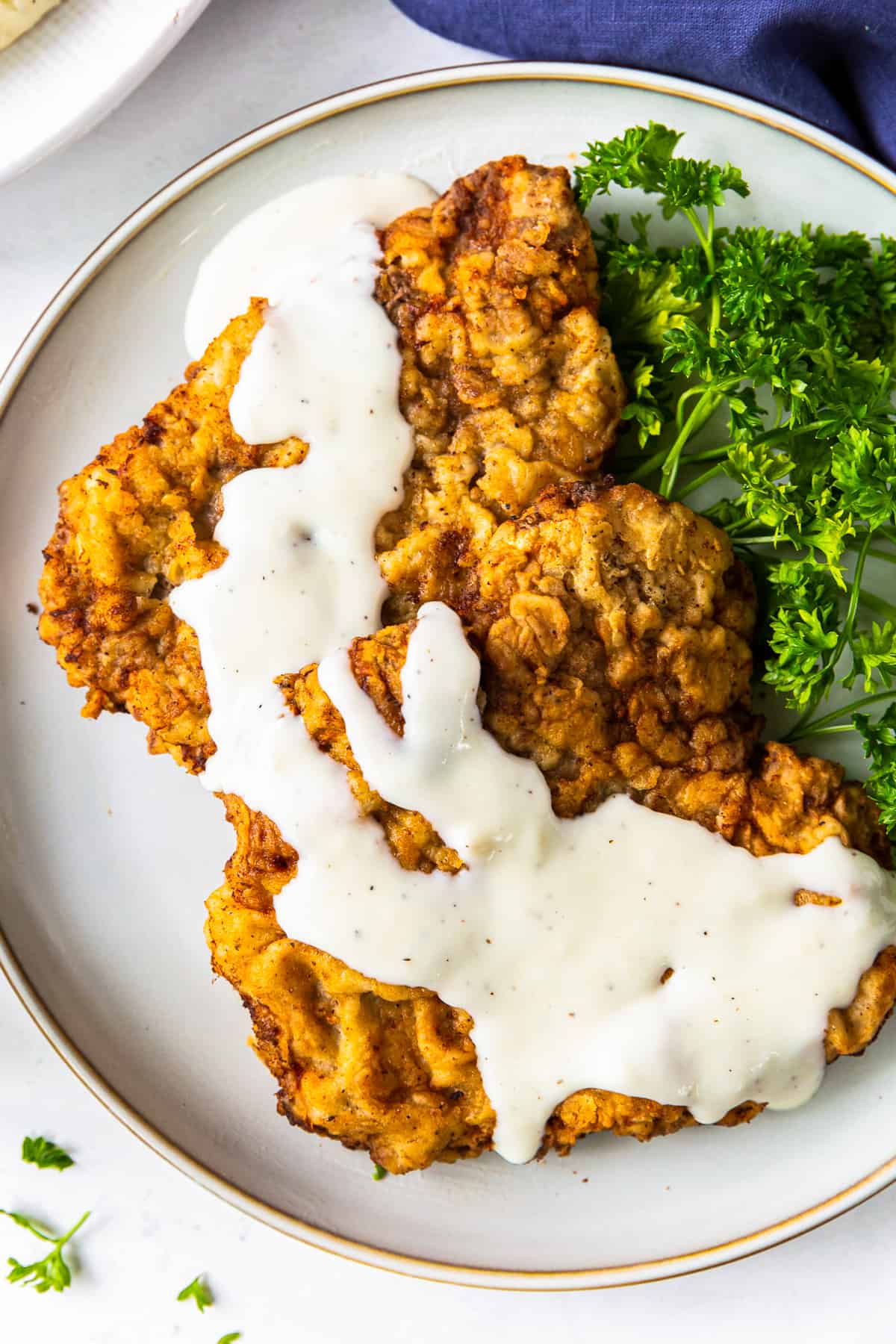 chicken fried steak with gravy on white plate