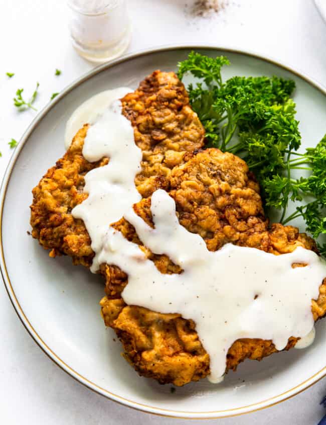 chicken fried steak with gravy on white plate