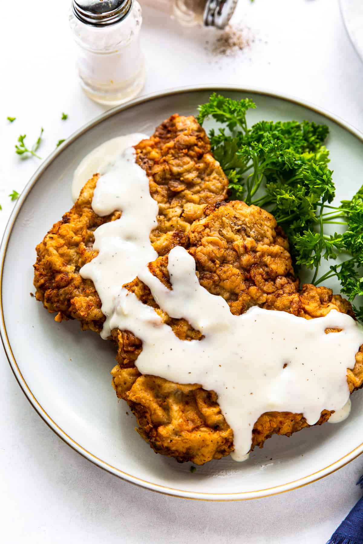 chicken fried steak with gravy on white plate